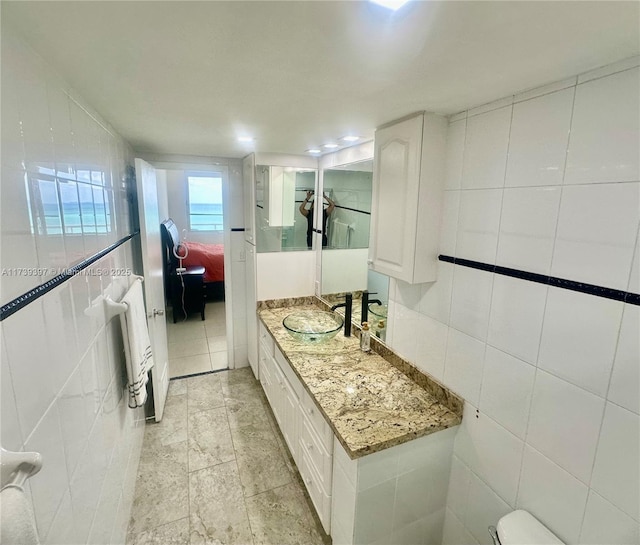 5005 Collins Ave Unit 1212, Miami Beach, FL 33140 - bathroom featuring tile walls, vanity, and ensuite bathroom