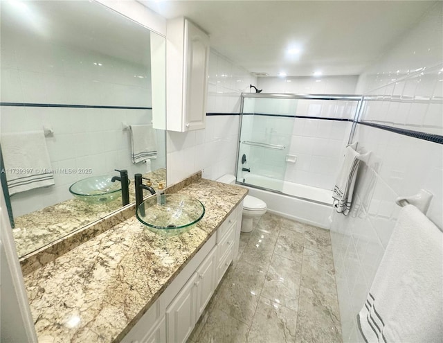 5005 Collins Ave Unit 1212, Miami Beach, FL 33140 - bathroom with tile walls, toilet, bath / shower combo with glass door, and vanity