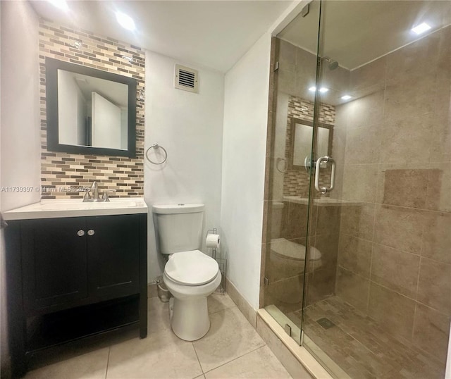 bathroom with toilet, vanity, visible vents, backsplash, and a stall shower