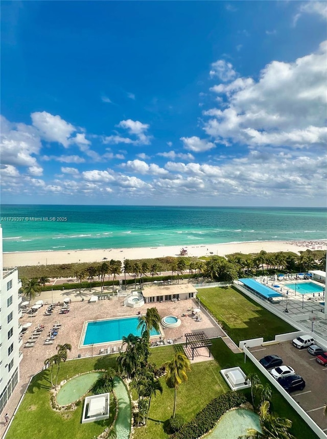 birds eye view of property featuring a water view and a beach view