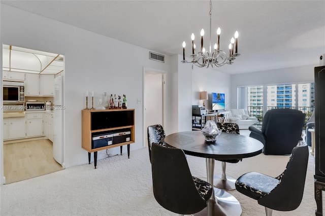 dining area featuring a chandelier and light carpet