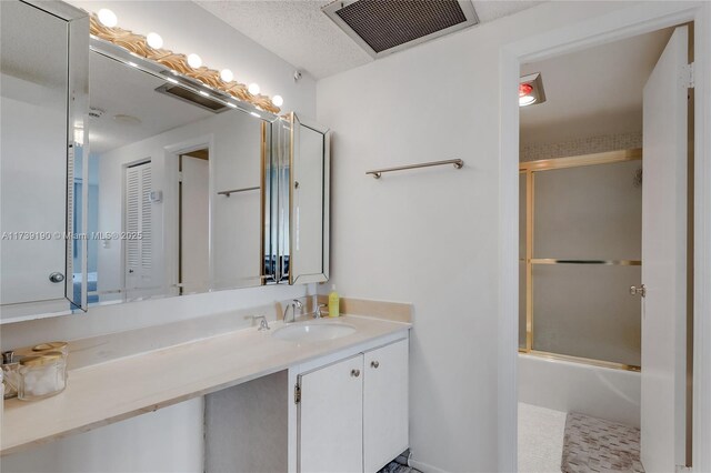 bathroom with enclosed tub / shower combo and vanity