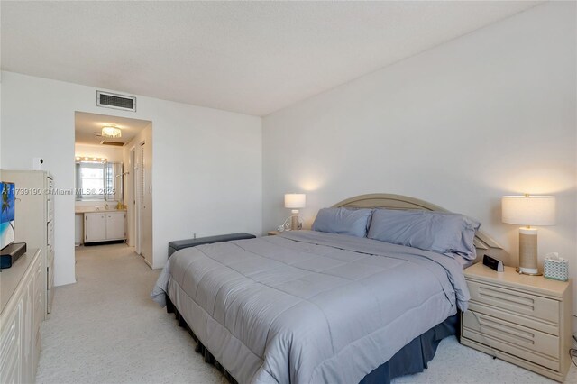 carpeted bedroom featuring ensuite bathroom