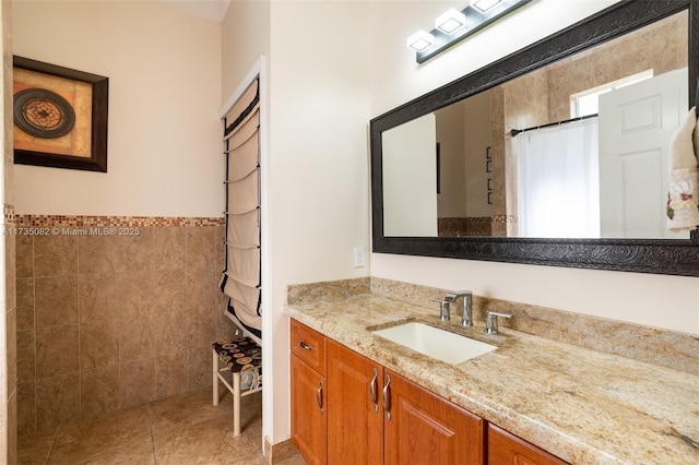 bathroom featuring tile walls, vanity, tile patterned floors, and walk in shower