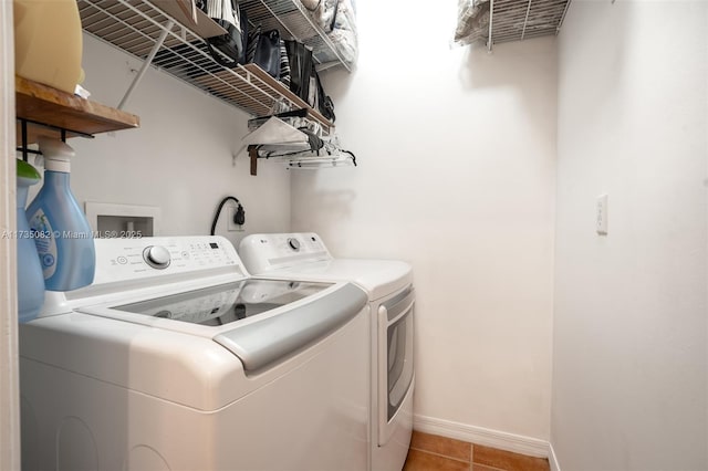 clothes washing area featuring light tile patterned floors and washer and clothes dryer