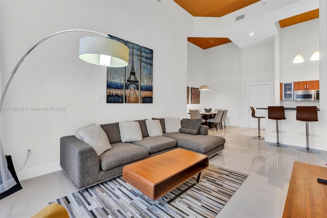 living room featuring light tile patterned flooring and a towering ceiling