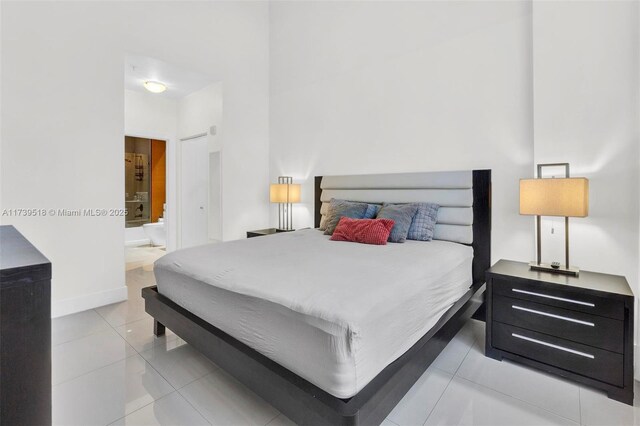 bedroom featuring light tile patterned flooring and ensuite bathroom