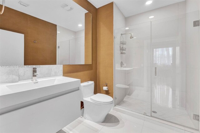 bathroom with vanity, a shower with shower door, tile patterned floors, and toilet