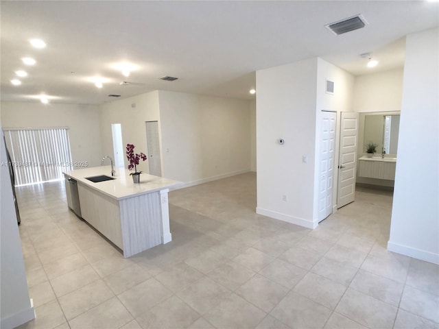 kitchen featuring baseboards, light countertops, a sink, and dishwasher