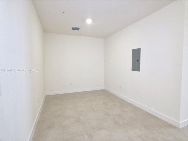 unfurnished room with visible vents, baseboards, and electric panel