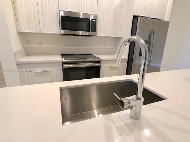 interior details featuring light countertops, modern cabinets, and appliances with stainless steel finishes