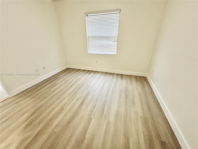 unfurnished room with baseboards and wood finished floors