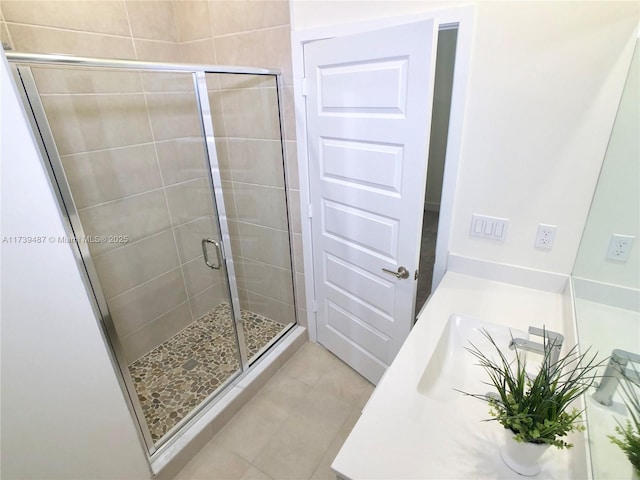 full bathroom featuring tile patterned floors, a sink, and a stall shower