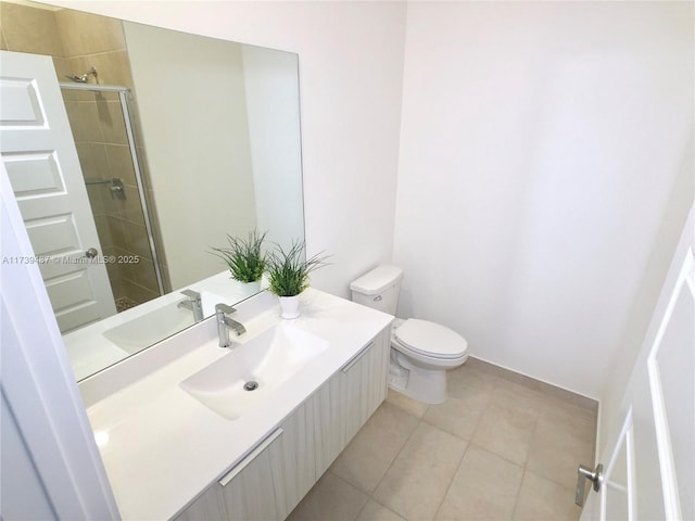 bathroom with tile patterned floors, toilet, tiled shower, and vanity