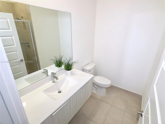 bathroom with an enclosed shower, vanity, tile patterned floors, and toilet