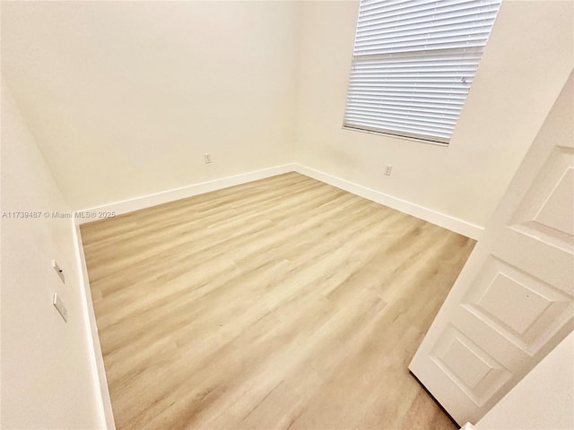 empty room featuring light wood-style flooring and baseboards