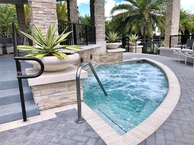 view of swimming pool featuring an in ground hot tub and a patio area