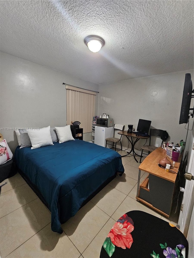 bedroom with light tile patterned floors and a textured ceiling