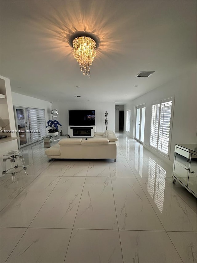 unfurnished living room featuring a notable chandelier