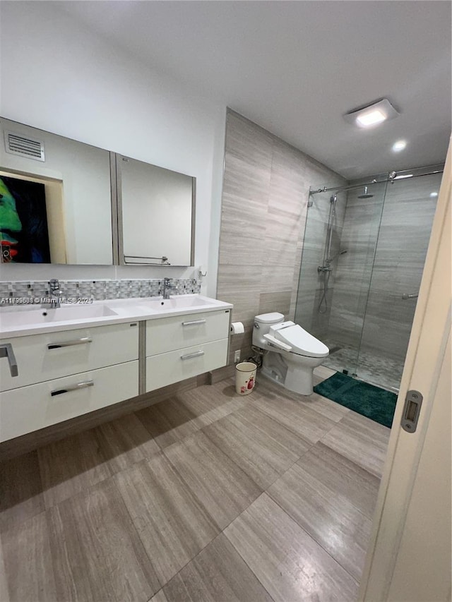 bathroom featuring tasteful backsplash, vanity, toilet, and an enclosed shower