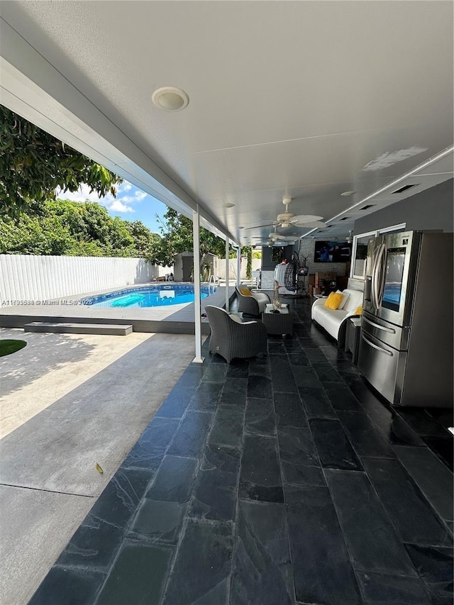 view of patio with a fenced in pool and ceiling fan