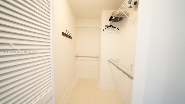 spacious closet with light tile patterned floors