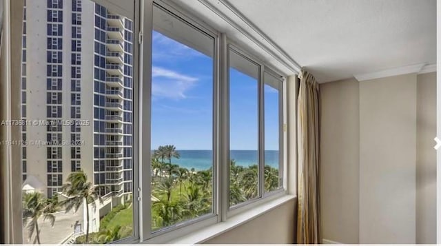 empty room featuring a water view and crown molding