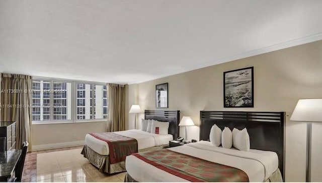 bedroom featuring light tile patterned flooring, crown molding, and baseboards