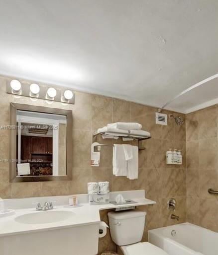 full bath with visible vents, toilet, shower / bathtub combination, vanity, and tile walls