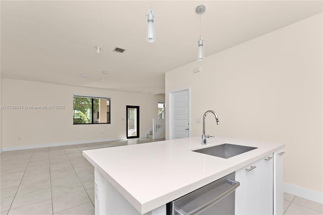 kitchen featuring white cabinetry, an island with sink, sink, dishwasher, and light tile patterned flooring