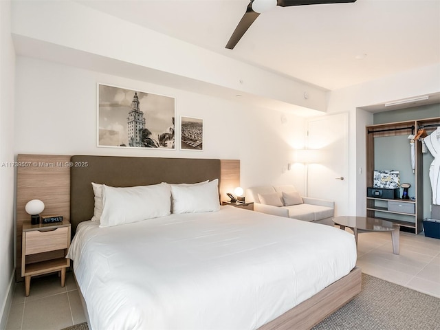 tiled bedroom with ceiling fan and a closet