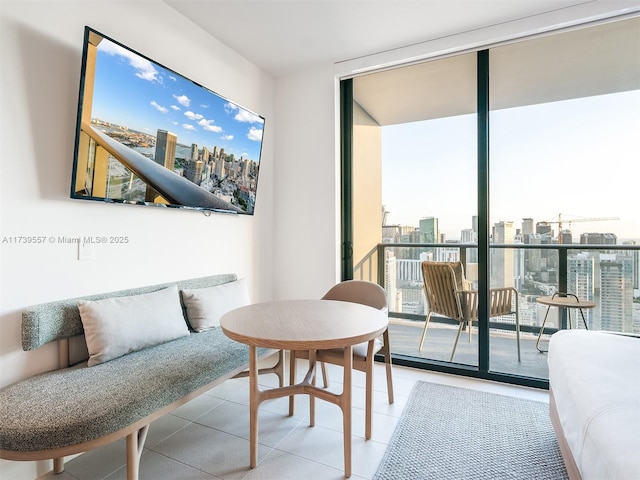 living area featuring light tile patterned flooring and a wall of windows