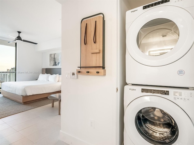 washroom with ceiling fan, stacked washer and dryer, and light tile patterned floors