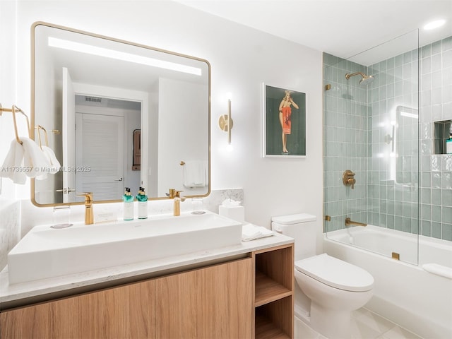 full bathroom with tiled shower / bath combo, vanity, and toilet