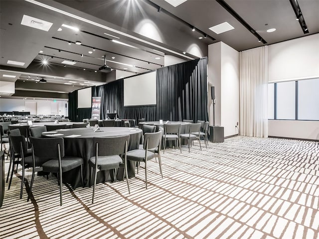 interior space with track lighting and light colored carpet