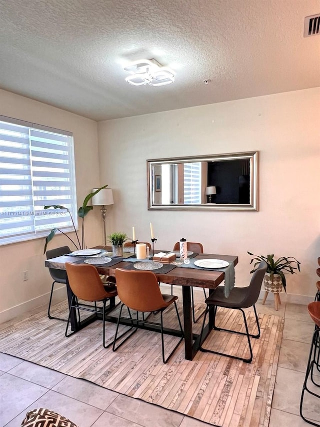 dining area with light tile patterned flooring and a textured ceiling