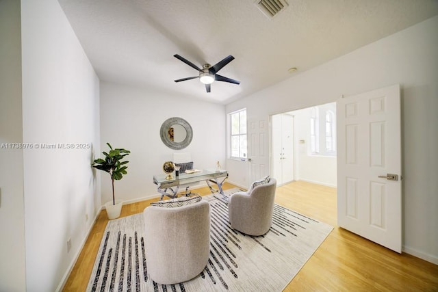 living room featuring ceiling fan and light hardwood / wood-style floors