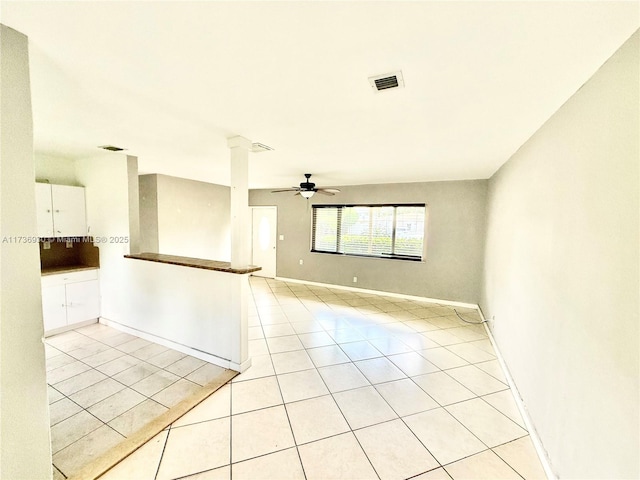 unfurnished room featuring decorative columns, visible vents, baseboards, ceiling fan, and light tile patterned flooring