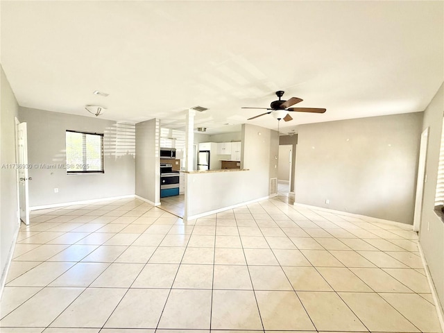 unfurnished living room featuring ceiling fan and light tile patterned floors