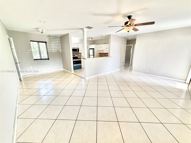 unfurnished living room with light tile patterned floors, ceiling fan, and ornate columns