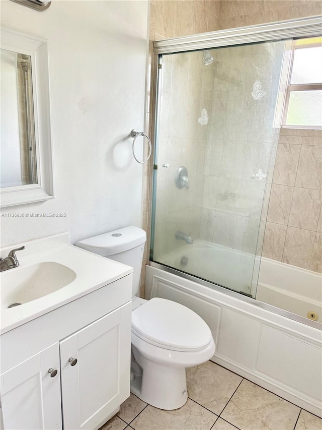 full bathroom featuring toilet, vanity, bath / shower combo with glass door, and tile patterned flooring