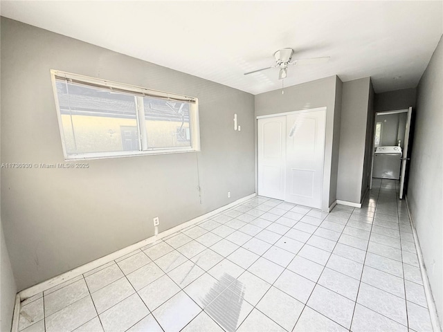 unfurnished bedroom featuring light tile patterned flooring, ceiling fan, washer / clothes dryer, and a closet