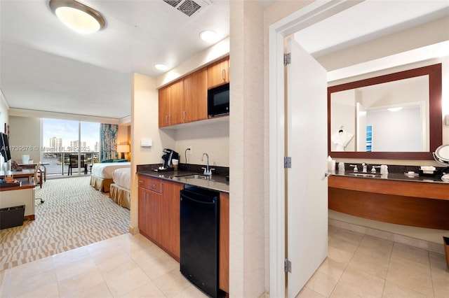 kitchen featuring light tile patterned flooring, expansive windows, sink, and black appliances