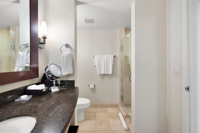 bathroom with tile patterned flooring, vanity, toilet, and walk in shower