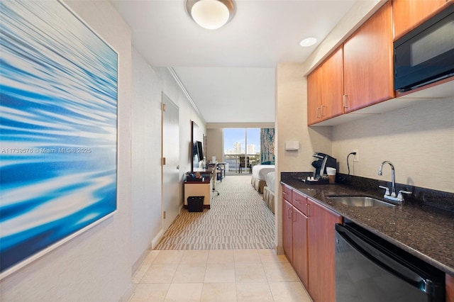 kitchen featuring dishwasher, sink, light tile patterned flooring, and dark stone counters