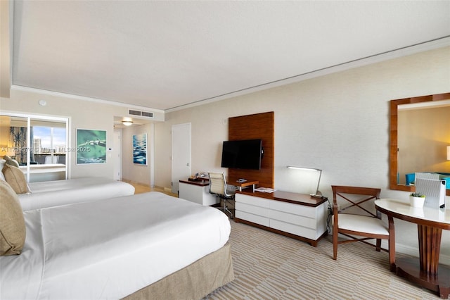 bedroom with ornamental molding and light carpet