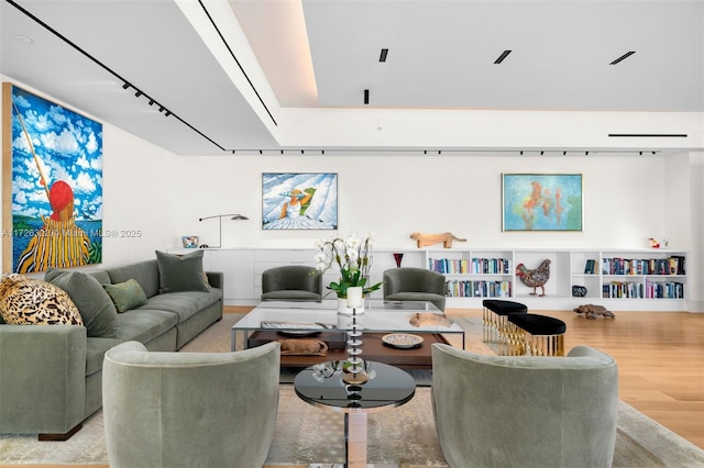 living room with rail lighting and light wood-type flooring