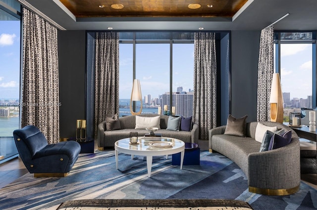 living room featuring a raised ceiling and floor to ceiling windows