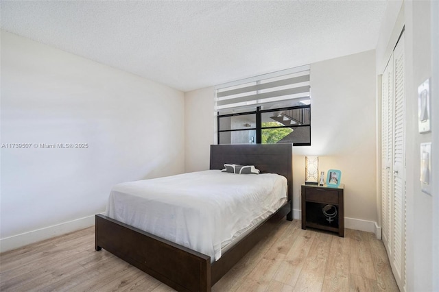 bedroom with light hardwood / wood-style flooring and a textured ceiling