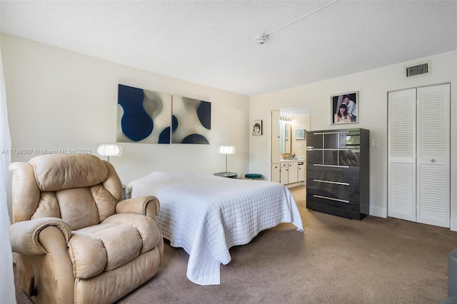 carpeted bedroom featuring ensuite bath, a closet, and a textured ceiling